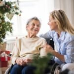 Senior woman in a wheelchair with a home health visitor
