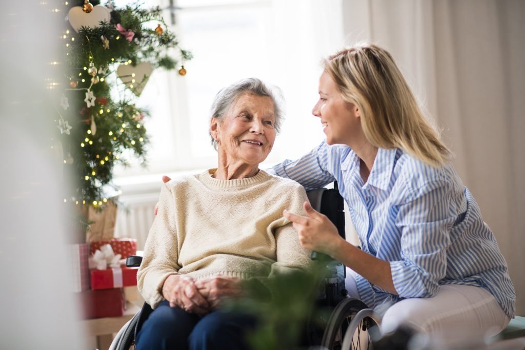 Senior woman in a wheelchair with a home health visitor