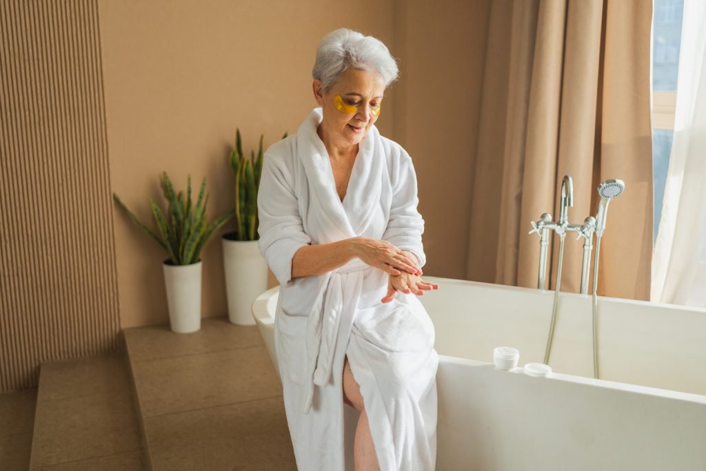 Senior applying lotion outside of a bathtub