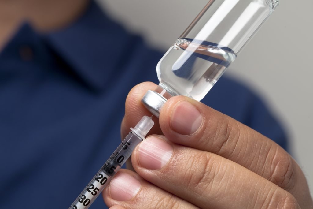 Nurse preparing a syringe for an insulin shot