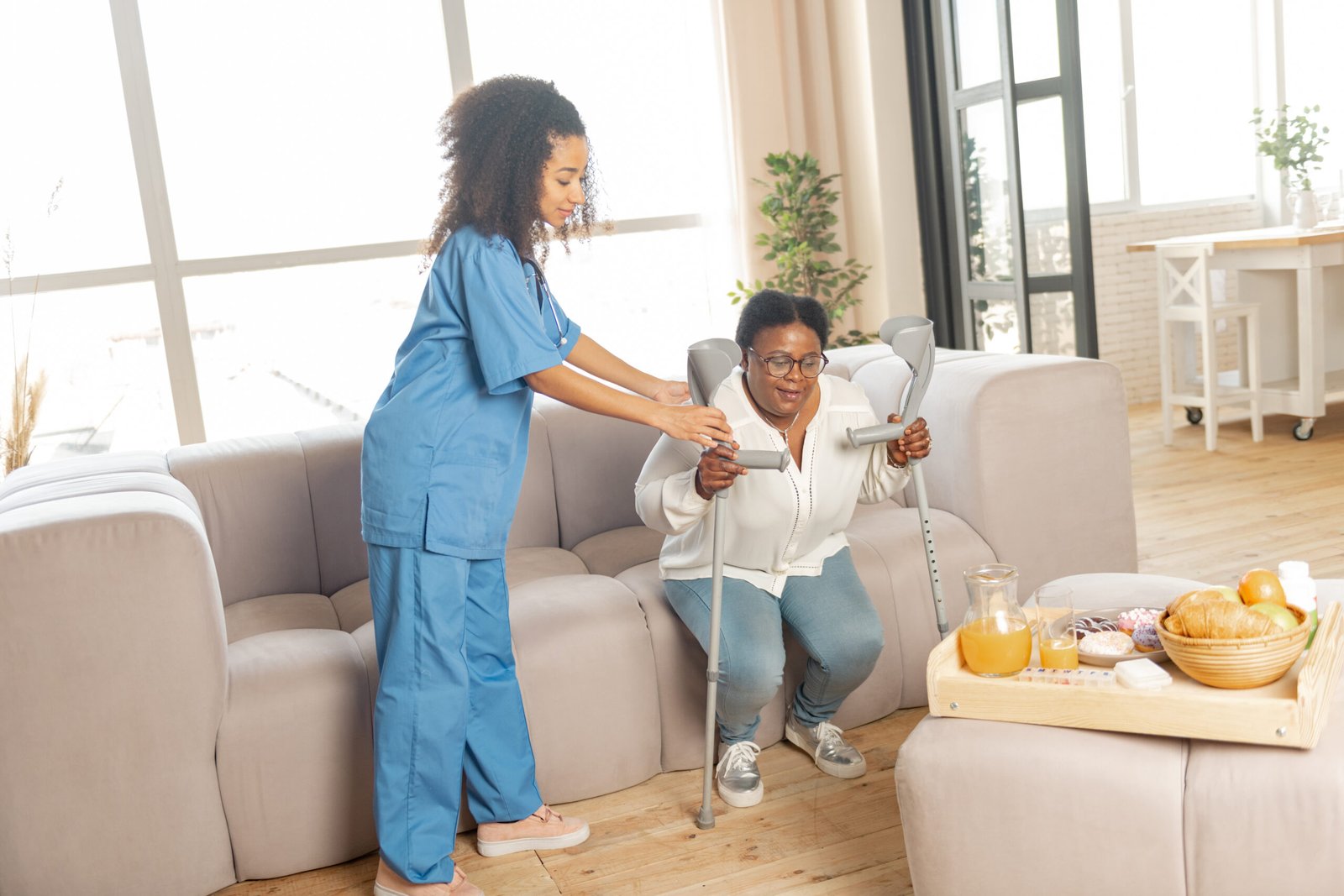Caregiver holding hands with a senior client at home